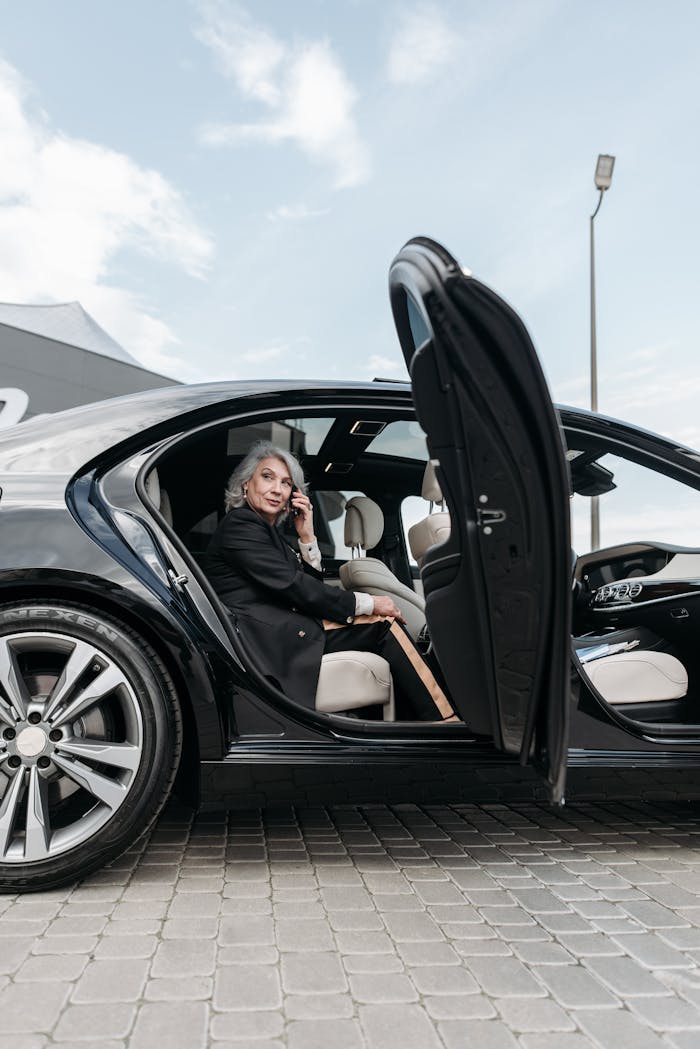 approach-img Confident senior woman sitting in a black luxury car, exuding elegance and success.